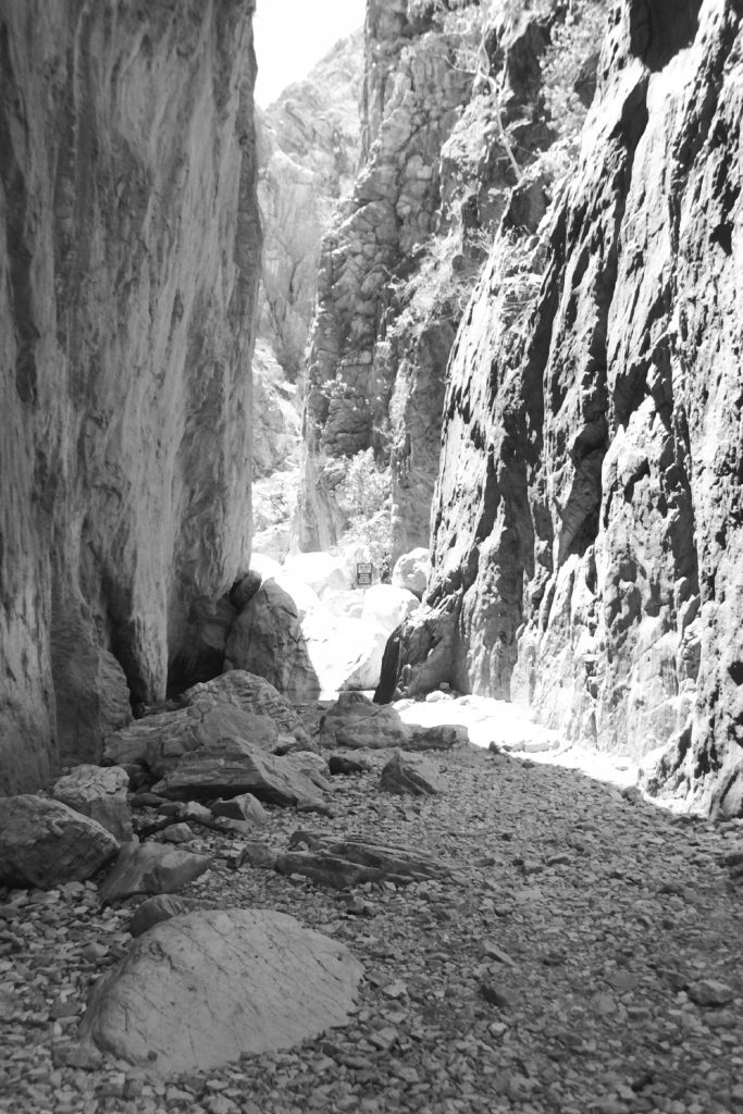 Black and white photograph of the gap between two almost sheer rock faces