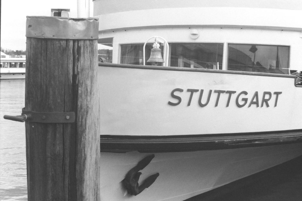 Black and white photograph of the front of a moored boat with the name Stuttgart on the side