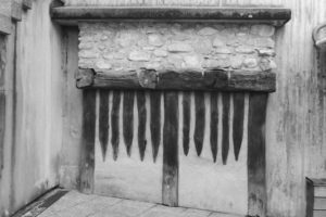 Black and white photograph of a wooden door with stone above it.