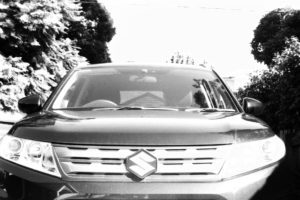 Black and white photograph close up of the front of an SUV