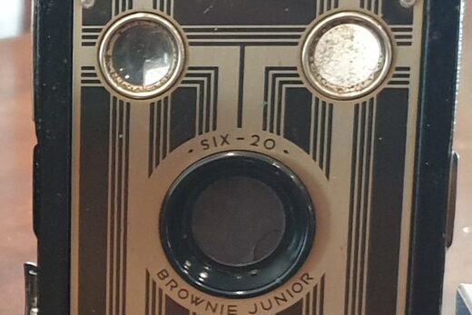 Colour photograph of a Kodak Six-20 Brownie Juinor box camera with an art deco design on the front.