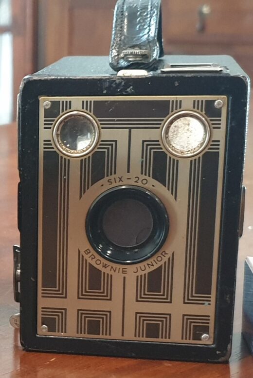 Colour photograph of a Kodak Six-20 Brownie Juinor box camera with an art deco design on the front.