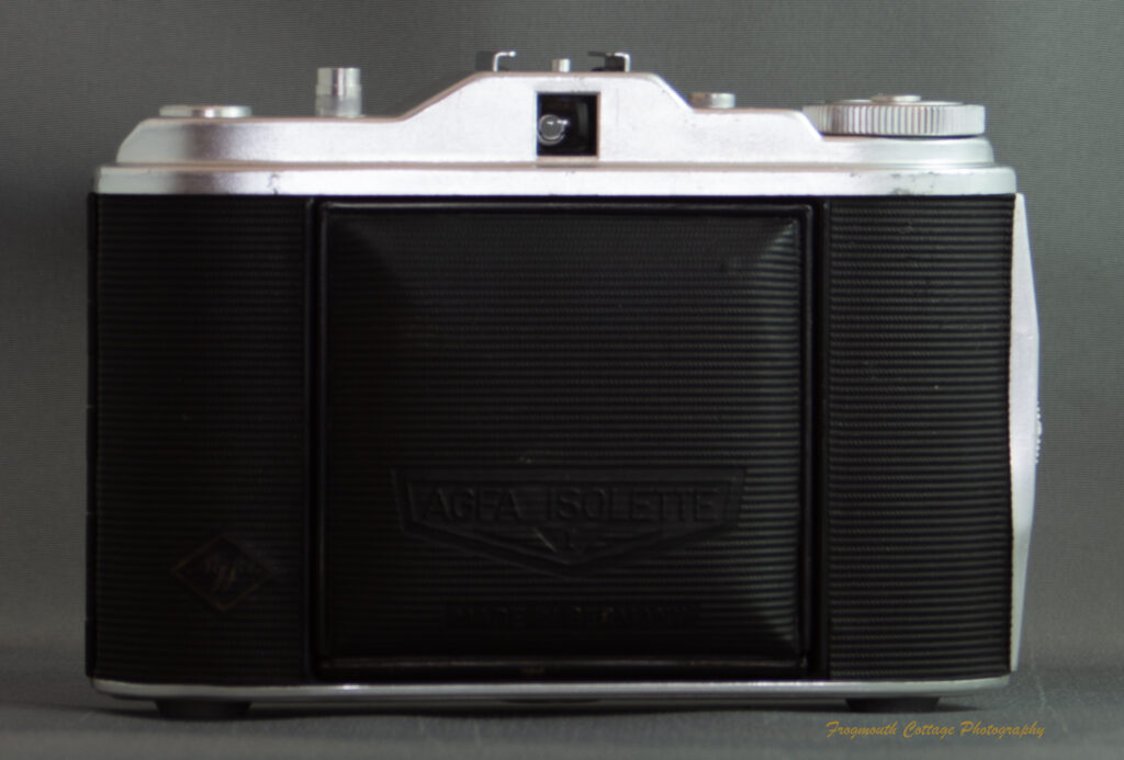 Photograph of an Agfa Isolette I camera - a folding medium format camera. The camera is closed with the bellows folded in. The words "Agfa Isolette" are printed on the front.