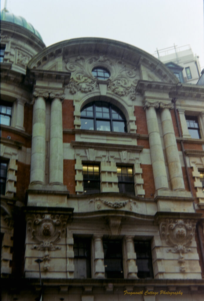 Photograph of an ornately decorated building facade. It has columns, domes, arched windows and decorative masonry.